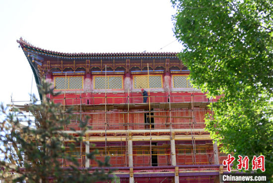 圖為5月上旬，甘肅山丹縣大佛寺內(nèi)，工作人員對(duì)古建筑大雄寶殿進(jìn)行修繕。 中新社記者 高展 攝