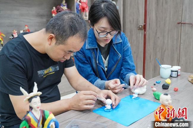 <a target='_blank'  data-cke-saved- >中新社</a>記者(右)現(xiàn)場體驗面塑制作過程?！￡悹帍?攝