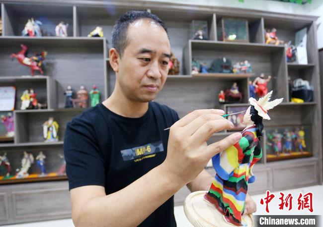 圖為安秋平正在創(chuàng)作代表隴南文縣民俗的《白馬人》作品。　高展 攝