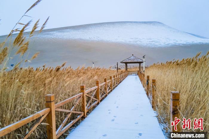 2021年11月28日，在敦煌鳴沙山月牙泉景區(qū)，沙雪交融，更顯北國(guó)風(fēng)情?！⊥醣筱y 攝