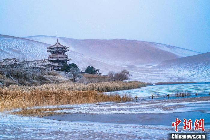 2021年11月28日，雪落鳴沙山月牙泉景區(qū)?！⊥醣筱y 攝