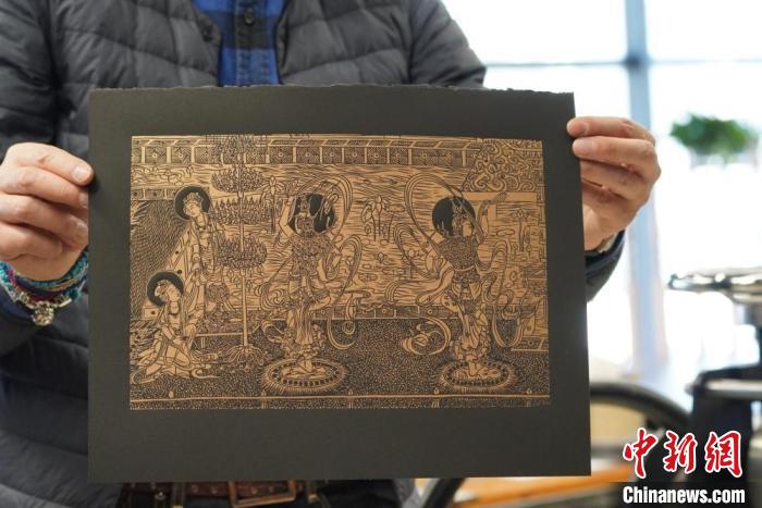 圖為手工書藝人展示敦煌雕版壁畫印刷品?！【琶赖┰?　攝