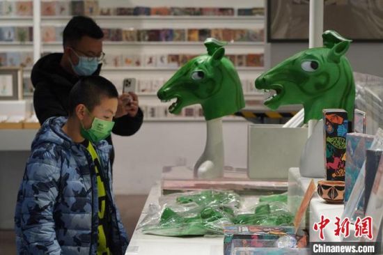 圖為“神馬來了”銅奔馬頭套吸引參觀者駐足?！【琶赖┰?攝