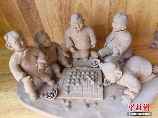 圖為泥塑作品展現(xiàn)下棋場景。 劉玉桃 攝