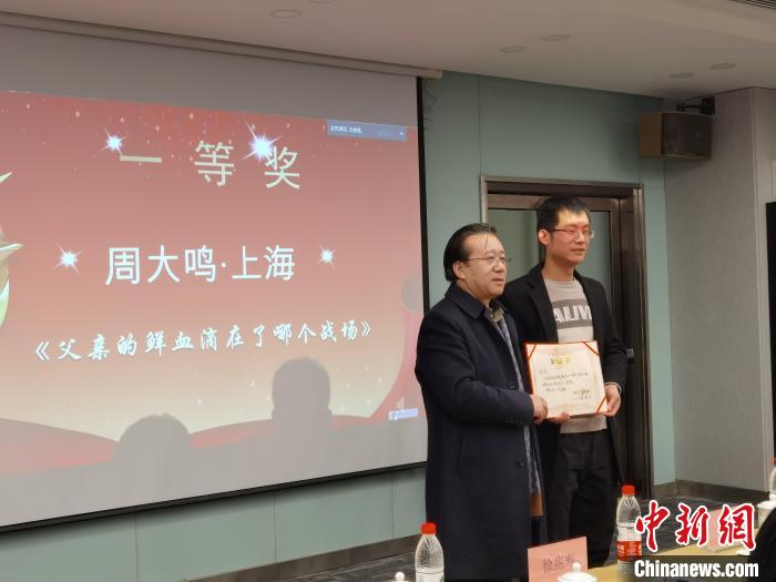圖為作家、西北師范大學新聞與傳媒學院院長徐兆壽頒發(fā)一等獎證書，代領獎者上臺領獎。　楊娜 攝