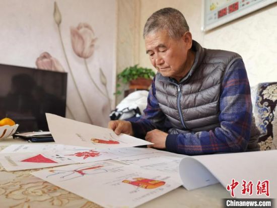 圖為陸鵬飛向記者展示多年帶隊(duì)的手寫筆記。　張婧 攝
