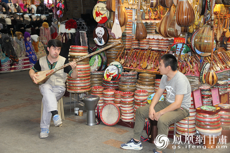 烏魯木齊二道橋巴扎內(nèi)，店主正在向客人展示樂器。楊文遠(yuǎn) 攝