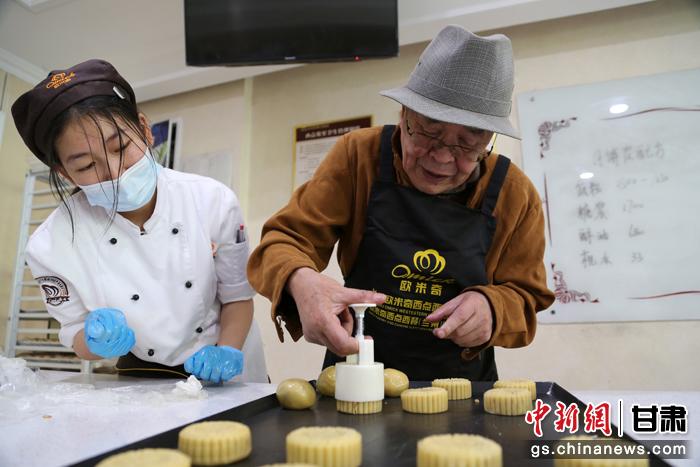 當(dāng)日，受邀參加活動(dòng)的臺(tái)胞臺(tái)屬代表、兩岸婚姻及子女、在甘臺(tái)商代表等歡聚一堂。圖為77歲的在甘臺(tái)胞潘天鑒制作月餅。九美旦增 攝
