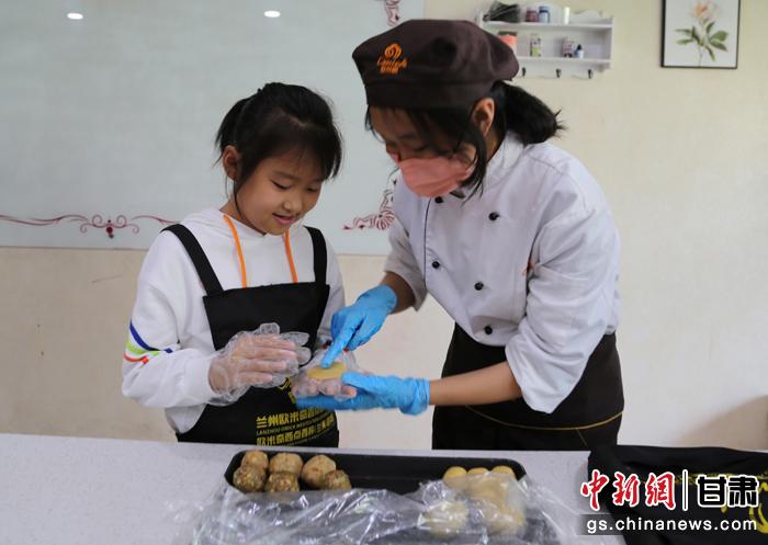 圖為在甘臺(tái)胞小朋友在工作人員指導(dǎo)下制作月餅。九美旦增 攝