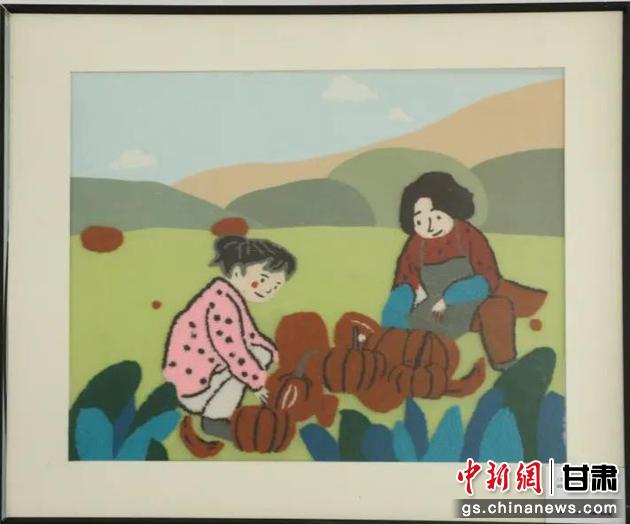 嘉峪關(guān)市新城鎮(zhèn)新城村農(nóng)業(yè)產(chǎn)業(yè)園區(qū)內(nèi)，母女兩人在摘南瓜。刺繡 馬艾米乃 繡稿 敬紅霞