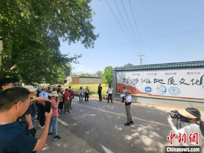 圖為中國地質(zhì)大學(xué)(北京)教授張緒教介紹村落情況。　胡友軍 攝