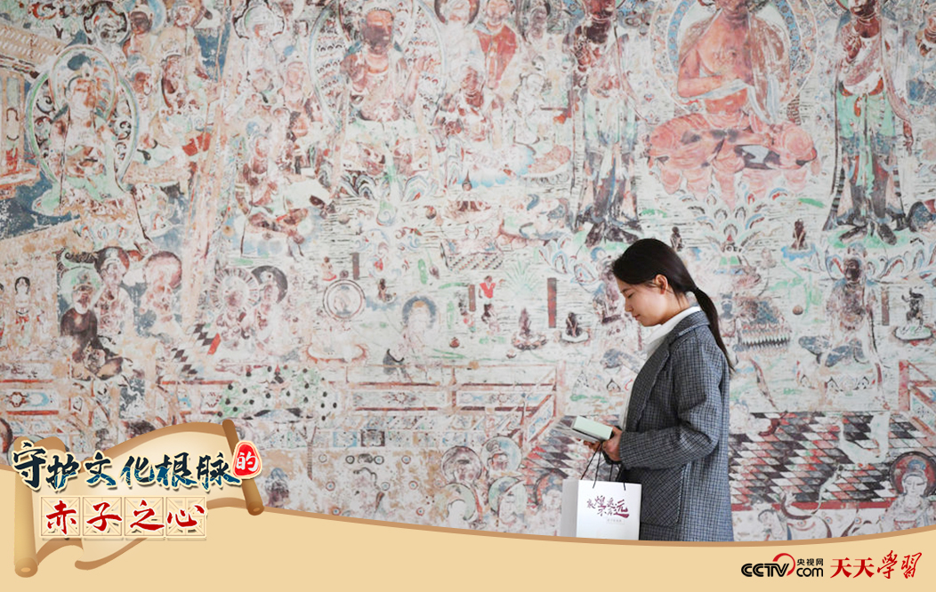 2023年4月25日，敦煌研究院文物數(shù)字化保護(hù)團(tuán)隊(duì)創(chuàng)意營(yíng)銷人員廖雪婷從一幅高保真復(fù)制壁畫前走過(guò)。