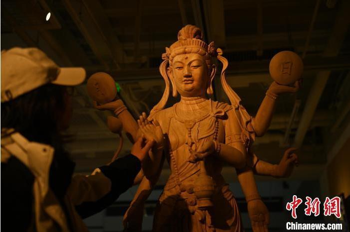圖為季茂杰觀察自己創(chuàng)作的敦煌木雕。李亞龍 攝</p>
<p>