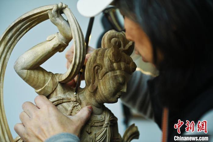 圖為季茂杰進(jìn)行敦煌元素的木雕創(chuàng)作。李亞龍 攝</p>
<p>
